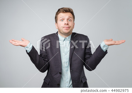 Young caucasian man in suit and white shirt is confused 44982975