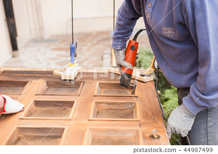 Carpenter at work with angular Sander. Carpenter at work with angular Sander. 44987499