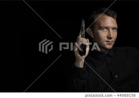 young man close up portrait, on black with pistol young man close up portrait, on black with pistol 44989156