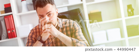A man is sitting at a table in the office. A man is sitting at a table in the office. 44990447