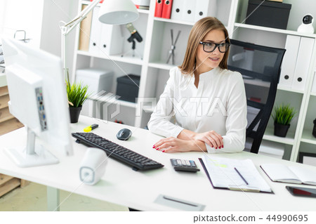 Portrait of a young girl in the office at the table. 44990695