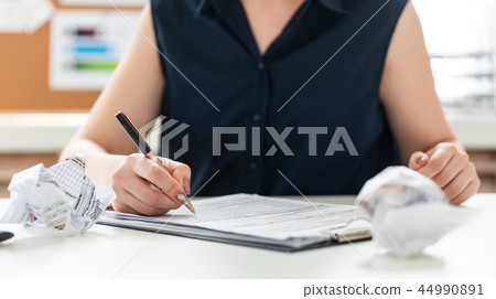 Women's hands fill out a questionnaire. 44990891