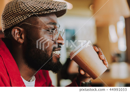 Close up of bearded man smiling and drinking coffee Close up of bearded man smiling and drinking coffee 44991033