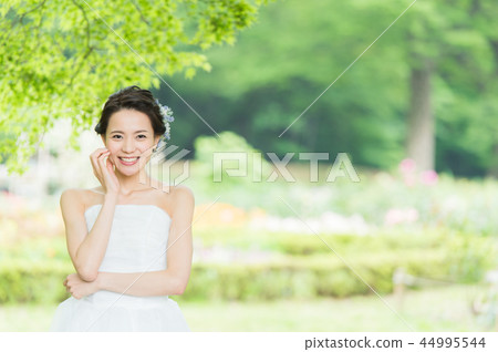 一個穿著婚紗的女人在綠樹叢中 44995544