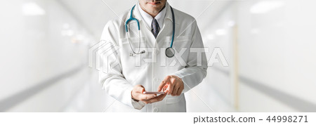 Male doctor using mobile phone at hospital. Male doctor using mobile phone at hospital. 44998271