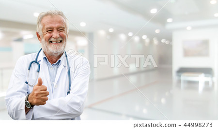 Happy senior doctor standing in the hospital. Happy senior doctor standing in the hospital. 44998273