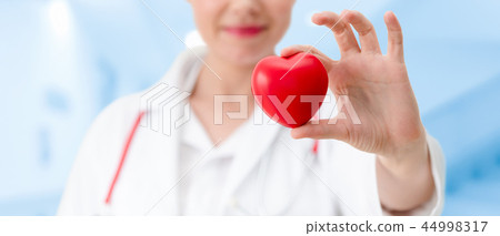 Doctor holding a red heart at hospital office. 44998317