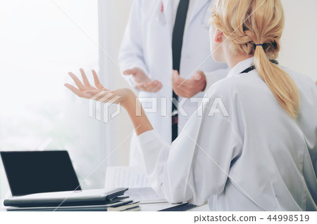 Female doctor at hospital talking to her partner. 44998519