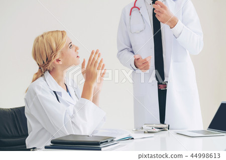 Female doctor at hospital talking to her partner. 44998613