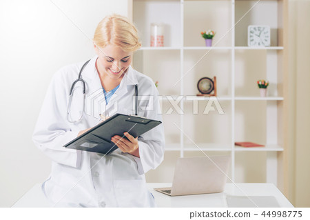 Young female doctor working in hospital office. 44998775