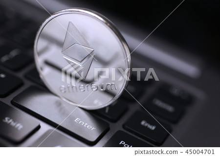 Silver ethereum coin is lying on laptop Silver ethereum coin is lying on laptop 45004701