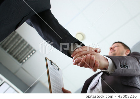 Man in suit shake hand as hello in office Man in suit shake hand as hello in office 45005210