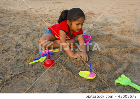 Little girl trying to make sand fort, Alibag beach Little girl trying to make sand fort, Alibag beach 45005672