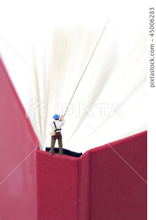 Miniature man fishing from above with red book 45006283
