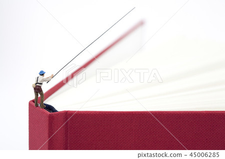 Miniature man fishing from above with red book 45006285
