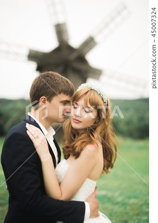 Emotional beautiful bride hugging newlywed groom at a field closeup Emotional beautiful bride hugging newlywed groom at a field closeup 45007324
