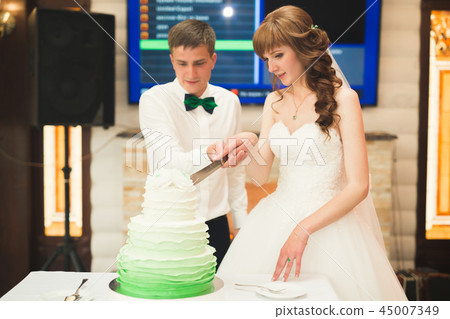 Bride and groom at wedding cutting the wedding cake Bride and groom at wedding cutting the wedding cake 45007349