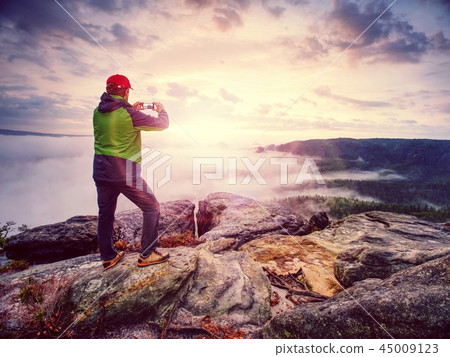 Blogger taking photo by smartphone of fall sunset 45009123