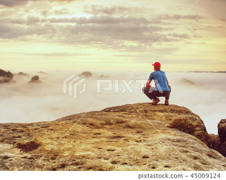 Man observe fall daybreak on peak of rock empire 45009124
