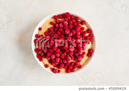 Cranberries adding to a sweet dough for muffins Cranberries adding to a sweet dough for muffins 45009429