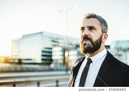 Hipster businessman walking on the street in the city. Copy space. 45009485