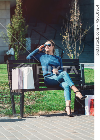 Beautiful girl with paper bags outside shopping mall 45010914