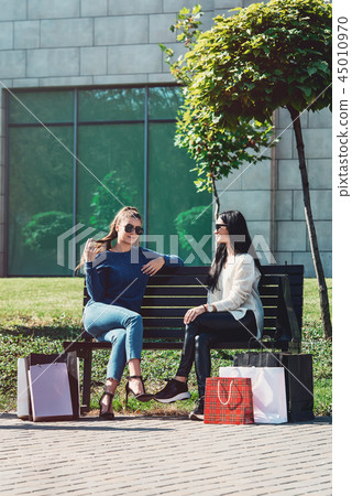 Beautiful girls with paper bags outside shopping mall 45010970