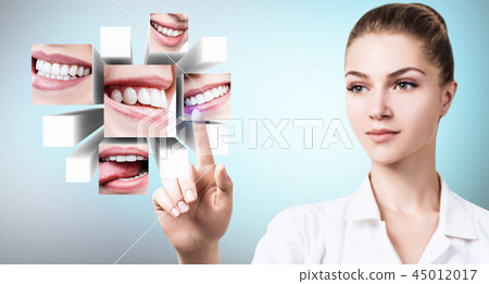 Dentist doctor pointing with finger on collage of healthy beautiful smiles. 45012017