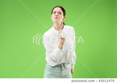 Portrait of an angry woman looking at camera isolated on a green background Portrait of an angry woman looking at camera isolated on a green background 45012479