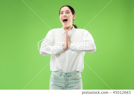 Beautiful woman looking suprised isolated on green 45012663
