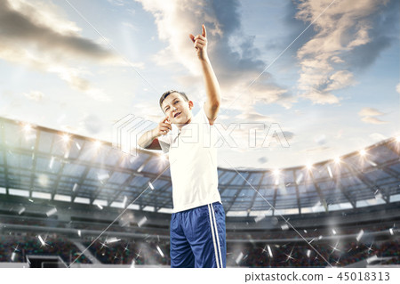 Young boy with soccer ball doing flying kick at stadium Young boy with soccer ball doing flying kick at stadium 45018313