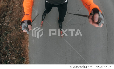 Training an athlete on the roller skaters. Biathlon ride on the roller skis with ski poles, in the 45018396