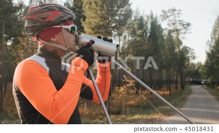 Training an athlete on the roller skaters. Biathlon ride on the roller skis with ski poles, in the 45018431