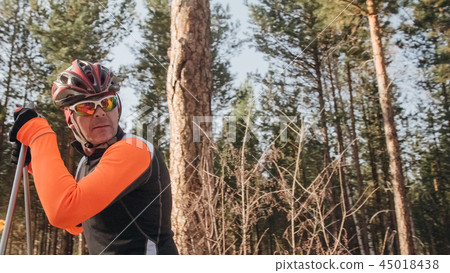 Training an athlete on the roller skaters. Biathlon ride on the roller skis with ski poles, in the 45018438