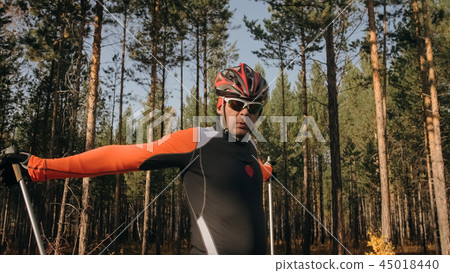 Training an athlete on the roller skaters. Biathlon ride on the roller skis with ski poles, in the Training an athlete on the roller skaters. Biathlon ride on the roller skis with ski poles, in the 45018440