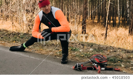 Training an athlete on the roller skaters. Biathlon ride on the roller skis with ski poles, in the Training an athlete on the roller skaters. Biathlon ride on the roller skis with ski poles, in the 45018503