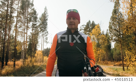Training an athlete on the roller skaters. Biathlon ride on the roller skis with ski poles, in the Training an athlete on the roller skaters. Biathlon ride on the roller skis with ski poles, in the 45018513