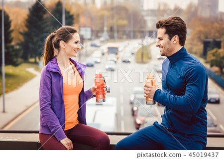 Woman and man drinking water in break from fitness training Woman and man drinking water in break from fitness training 45019437