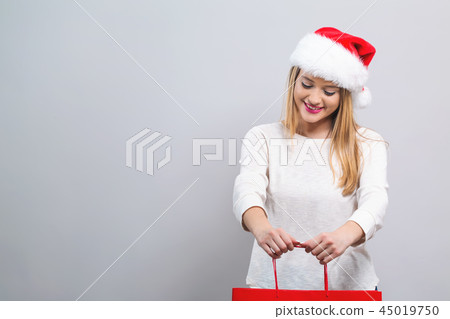 Young woman with santa hat holding a shopping bag 45019750