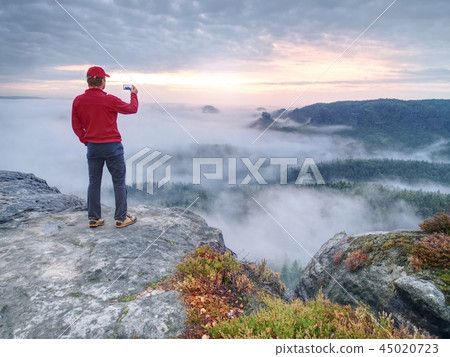 Tourist taking photos with touch screen phone 45020723