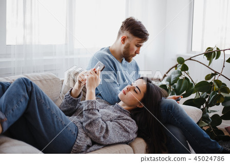 Couple with phones in living room 45024786
