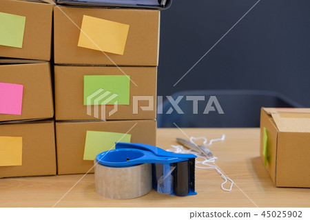 adhesive tape & parcel cardboard box. Online selling, e-commerce concept adhesive tape & parcel cardboard box. Online selling, e-commerce concept 45025902