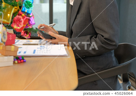 financial adviser use calculator to calculate revenue & budget. accountant doing accounting during christmas holiday financial adviser use calculator to calculate revenue & budget. accountant doing accounting during christmas holiday 45026064