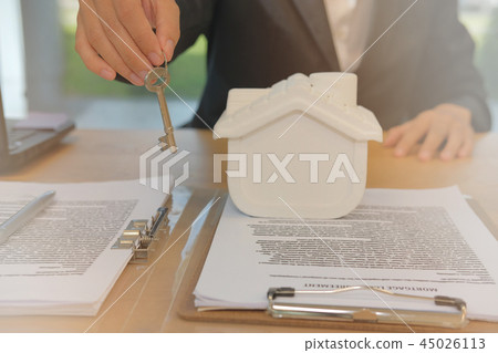 realtor agent with house model & key. buying renting real estate property. 45026113