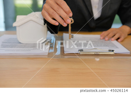 realtor agent with house model & key. buying renting real estate property. 45026114