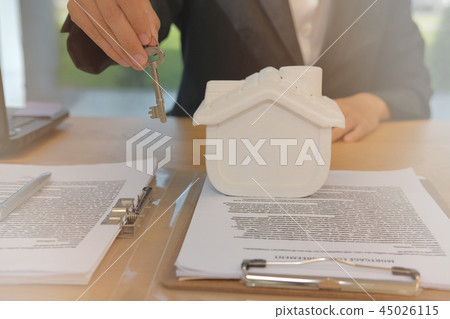 realtor agent with house model & key. buying renting real estate property. 45026115