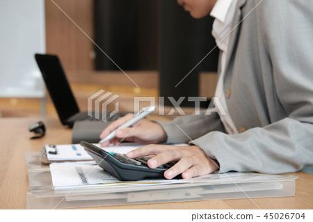 financial adviser use calculator to calculate revenue & budget. accountant doing accounting. bookkeeper making calculation. finance & economy concept financial adviser use calculator to calculate revenue & budget. accountant doing accounting. bookkeeper making calculation. finance & economy concept 45026704