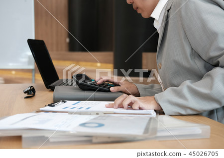 financial adviser use calculator to calculate revenue & budget. accountant doing accounting. bookkeeper making calculation. finance & economy concept financial adviser use calculator to calculate revenue & budget. accountant doing accounting. bookkeeper making calculation. finance & economy concept 45026705