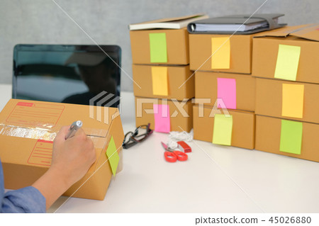 startup business owner writing address on cardboard box. woman seller prepare parcel box for delivery. Online selling, e-commerce concept startup business owner writing address on cardboard box. woman seller prepare parcel box for delivery. Online selling, e-commerce concept 45026880