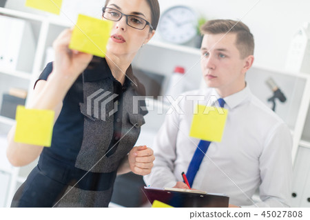 Young people are discussing in the office near the Board with stickers. 45027808